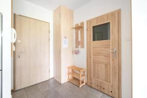 pasillo con puerta de madera y escalera en Apartament Lema en Gdansk