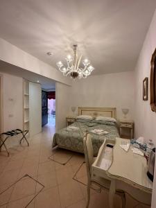 a bedroom with a bed and a table and a chandelier at Alloggi Santa Sofia in Venice