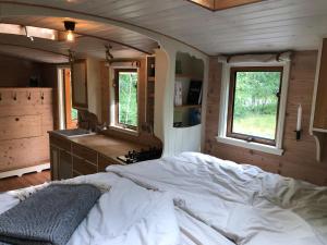 ein Schlafzimmer mit einem großen weißen Bett in einem Haus in der Unterkunft Tinyhouse auf Rädern in Grängesberg