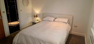 a bedroom with a bed with two pillows and a lamp at Mayfield guest rooms in Bromley