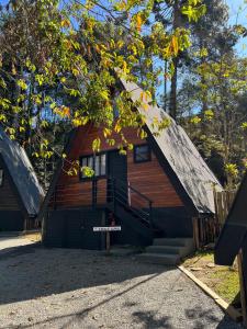une maison avec un toit en gambrel et des escaliers menant à la porte. dans l'établissement Chalé Villa Nature, à Campos do Jordão