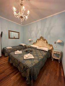 a bedroom with two beds and a chandelier at Alloggi Santa Sofia in Venice