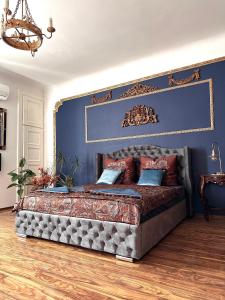 1 dormitorio con 1 cama grande y pared azul en Exclusive Apartment Chmielna Street 95m2, en Varsovia
