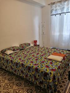 - une chambre avec un grand lit et une couverture colorée dans l'établissement Petit appart au cœur des REMPARTS - Netfix et connection fibre gratuits, à Carpentras