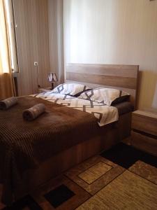 - une chambre avec un grand lit et une tête de lit en bois dans l'établissement House 1891, à Koutaïssi