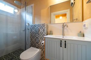 La salle de bains est pourvue de toilettes, d'un lavabo et d'une douche. dans l'établissement בריאה אירוח בטבע, à Sha'al