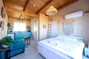 1 dormitorio con 1 cama grande y cocina en בריאה אירוח בטבע en Sha'al