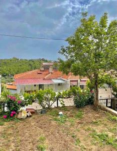 una casa con una recinzione e un albero di Plaja Yakın Dağ ve Deniz Manzaralı 1+1 Daire a Gokceada Town
