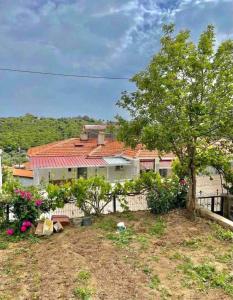 una casa con una valla y un árbol en Plaja Yakın Dağ ve Deniz Manzaralı 1+1 Daire, en Gokceada Town