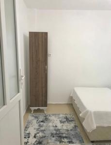 1 dormitorio con 1 cama y puerta de madera en Plaja Yakın Dağ ve Deniz Manzaralı 1+1 Daire, en Gokceada Town