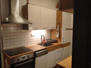 una cocina con armarios blancos y fregadero en Cosy private apartment in a family house, en Jirny