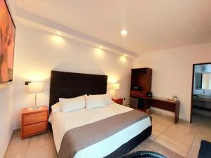 - une chambre avec un lit, une commode et une fenêtre dans l'établissement Casa Allende Morelia, à Morelia