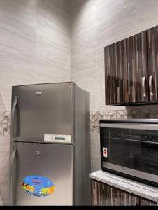 eine Küche mit einem Kühlschrank aus Edelstahl und einer Mikrowelle in der Unterkunft Oxygen hatta in Hatta