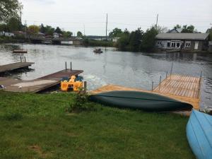 un petit bateau est garé à côté d'un quai dans l'établissement Balsam Lake Cottage 5 Bed room, à Kawartha Lakes