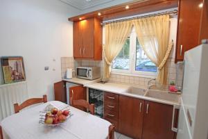 リトホロにあるKalliarchis Apartmentのキッチン(テーブル、フルーツボウル付)