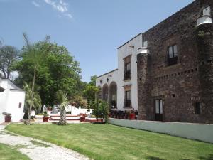 een uitzicht op een gebouw met een tuin bij Hotel Spa Hacienda Real la Nogalera in Tequisquiapan