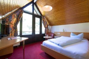 1 dormitorio con cama, escritorio y ventana en Hotel Strand-Café en Roßbach