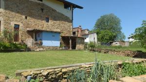 una vista exterior de una casa de piedra con patio en El Telar, en Rasines