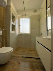 a bathroom with a toilet and a glass shower at Shehapi apartment in Kavajë +16 photos