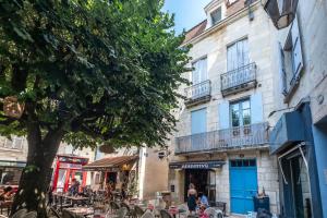 una calle con mesas y sillas frente a un edificio en Le Jardin Suspendu Charme & Calme en centre ville en Périgueux