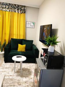 a living room with a green couch and a table at Indesign Makumbi park studio Apartment D4-5,Syokimau in Syokimau