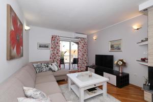 ein Wohnzimmer mit einem Sofa und einem TV in der Unterkunft Sea Relaxing Apartment in Bibinje