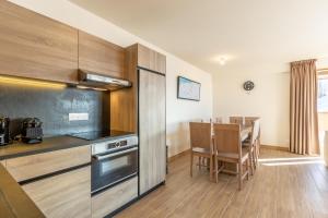 a kitchen and dining room with a table in it at Ridge302 in Bourg-Saint-Maurice