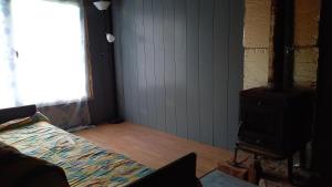 - une chambre avec un lit et un poêle à bois dans l'établissement Plesumi, 