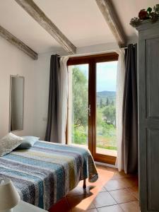 a bedroom with a bed and a large window at La Casa di Alice Turchese in Olbia