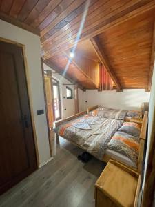 a large bed in a room with a wooden ceiling at natyra balcony in Valbonë +7 photos