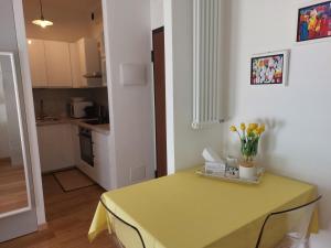 a kitchen with a yellow table with flowers on it at A UN PASSO DALL'OSPEDALE in Padova