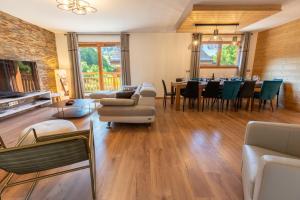 a living room filled with furniture and a dining room at Chalet Gaïla in Méribel