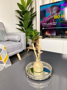 a living room with a vase on a table with a tv at Home in Medway in Gillingham