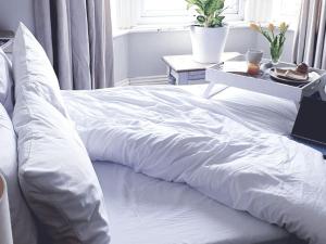 Una cama blanca con una manta blanca. en Sea Proche, en Sandown