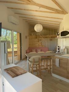 eine Küche und ein Wohnzimmer mit einem Tisch und Stühlen in der Unterkunft Chalet Cocoon in Laroque