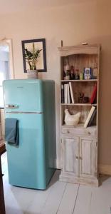 Sea Proche في سانداون: ثلاجة زرقاء في مطبخ مع خزانة
