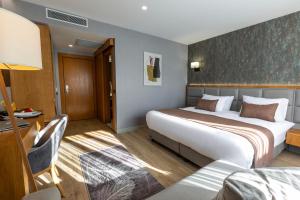 Habitación de hotel con 2 camas y escritorio en North Star Suite Hotel en Trebisonda