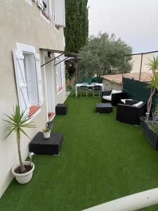 um quintal com um relvado verde com mobiliário nele em Villa Cocooning proche Cannes em Vallauris