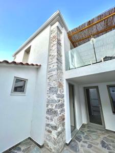 una casa bianca con un muro di pietra di Kefi House Skiathos a Città di Skiathos
