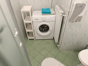 a washing machine in a bathroom with a toilet at Apartments Abc Ljubljana in Ljubljana