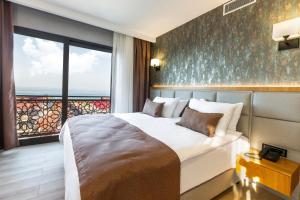 um quarto com uma cama grande e uma janela grande em North Star Suite Hotel em Trabzon