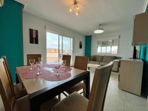 a dining room with a table with wine glasses on it at ACV - Torremar-2ª linea planta 7 Frontal in Oropesa del Mar