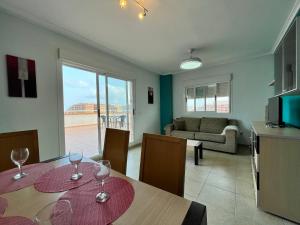una sala de estar con una mesa con copas de vino. en ACV - Torremar-2ª linea planta 7 Frontal, en Oropesa del Mar