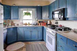 a blue kitchen with a stove and a microwave at Two bedrooms unit with jacuzzi and great view in Niagara Falls