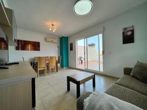 a kitchen and living room with a couch and a table at ACV - Torremar-2ª linea planta 7 Frontal in Oropesa del Mar