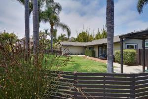 a house with palm trees and a fence at Coastal Retreat with E-Bikes! in Carlsbad