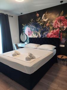 Apartman MariLu في Drašnice: غرفة نوم بسرير كبير عليها لوحة على الحائط