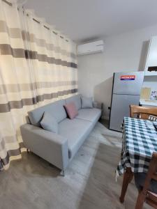een woonkamer met een blauwe bank met 2 kussens bij Small Studio near the Olimpik Park in Tirana