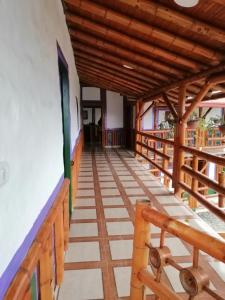 - une vue sur le couloir d'une maison avec balustrade en bois dans l'établissement Casa el edén, à Choachí