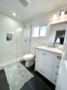 een witte badkamer met een douche, een toilet en een wastafel bij STUDIO-Beach-LAX SPC-X- EL-SEGUNDO-AIR-FORCEBASE in Inglewood